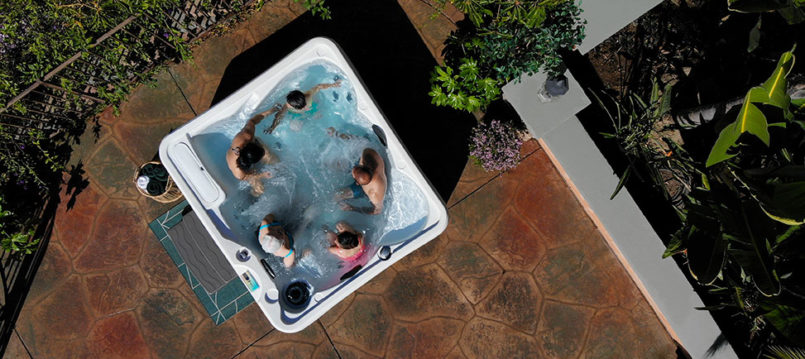 overhead photo of a white and brown hot tub with happy family